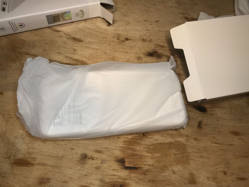 Powerbank JR-QP194 zapakowany w plastikową folię na drewnianym stole.
