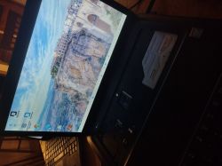 Ekran laptopa z uruchomionym systemem Windows i zdjęciem miasta w tle
