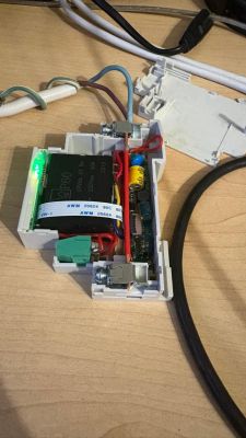 Open housing of an electrical device showing a circuit board, wires, and a large MP60 component on a desk