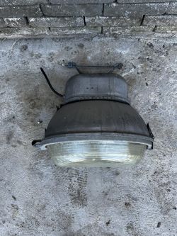Lampa przemysłowa PREDOM-MESKO OURP-250 na podłodze z betonu.