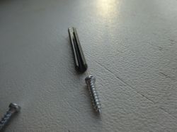 Screws and Pin on Surface Close-up of screws and a metal pin lying on a surface.