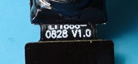 Close-up of a camera ribbon labeled “0828 V1.0” on a black surface