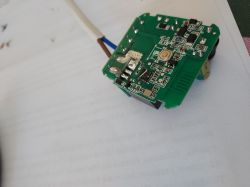 Colorful circuit board with a thin leg soldered onto it.