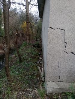 Ściana garażu z widocznymi pęknięciami.