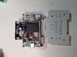 Open device housing showing a transformer, circuit board, and wires, with the removed cover placed beside it