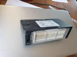 Xiaomi 2-in-1 vacuum container on a silver laptop, visible filter and instruction label.