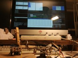 Desk with electronics and a computer displaying data on the screen.