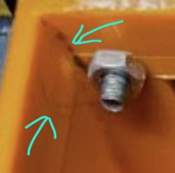 Close-up of orange housing corner with crack and metal screw