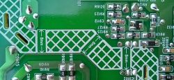 Zbliżenie na tylną część płytki drukowanej PCB z widocznymi oznaczeniami elementów i polami lutowniczymi.