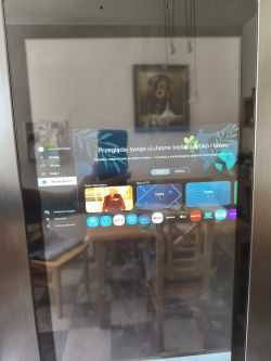 Ekran lodówki pokazujący interfejs Smart Hub z aplikacjami i podglądem TV