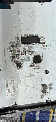 Internal view of electronic device with PCB and various mounted components.