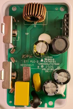 Close-up of a circuit board with various electronic components, including a coil, capacitors, and resistors.