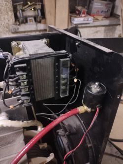 Wnętrze spawarki z transformatorem, okablowaniem i elektrozaworem gazu z czerwonym wężem