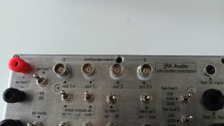 Panel przedni urządzenia do pomiaru wzmacniaczy audio z różnymi złączami i przełącznikami.