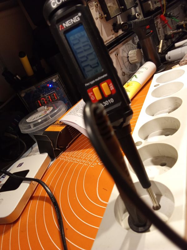 Miernik elektryczny w kształcie wkrętaka marki ANENG na biurku warsztatowym.