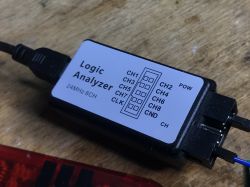 24MHz 8-Channel Logic Analyzer Logic analyzer connected to a computer on a wooden surface.