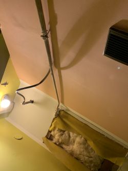Rura instalacyjna na suficie z odsłoniętą izolacją.