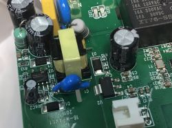 Close-up of the ATLO-S1IP5-TUYA socket power supply PCB, showing capacitors, SMD components, and a transformer.