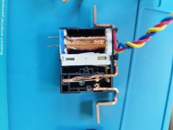 Electromagnet with visible copper coil on a blue background.