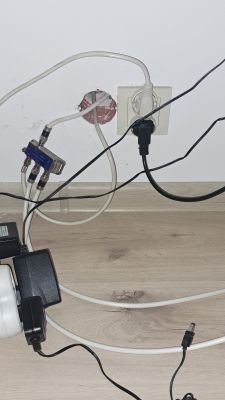 Zdjęcie ściany z kablami i rozgałęźnikiem antenowym oraz gniazdkiem elektrycznym.