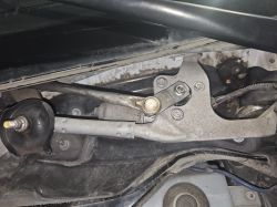 Mechanizm wycieraczek samochodowych pod maską pojazdu.
