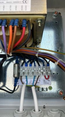 Rozdzielnia elektryczna z listwą zaciskową, na której widoczne są przewody podłączone do oznaczeń L1 OUT oraz U.