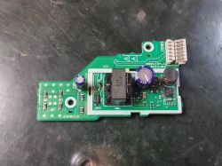 Płytka drukowana z elementami elektronicznymi, w tym kondensatorami i cewką.