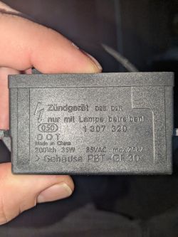 Zbliżenie na czarną obudowę z oznaczeniami technicznymi.