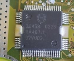 Zbliżenie układu scalonego z oznaczeniami 30458 RA467.1 na płytce drukowanej.
