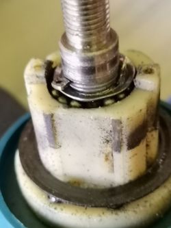 Close-up of a damaged drill bearing with visible crack in the plastic ring.