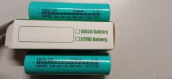 Dwie zielone ogniwa HAKADI Na-Ion 18650 oraz kartonik z napisem „18650 Battery”