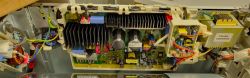 Zbliżenie na wnętrze elektronicznej płytki suszarki LG z widocznymi przewodami i komponentami.