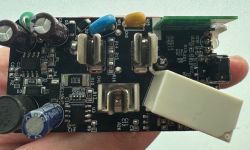 Circuit Board of Smart Plug with Components Circuit board with electronic components held in a hand.