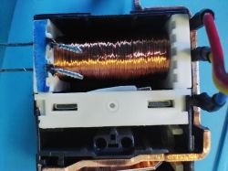 Close-up of a solenoid coil with copper wire in a plastic casing.