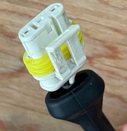 Przewód elektroniczny z białą wtyczką i żółtym obramowaniem.