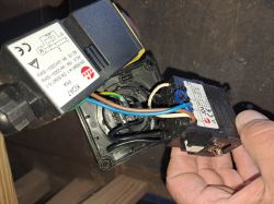 Dwa podzespoły elektroniczne z widocznymi oznaczeniami, trzymane w ręce.