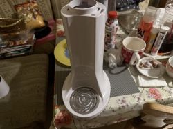 Biały saturator Levivo bez butelki, ustawiony na stole kuchennym