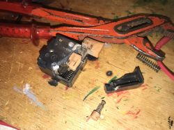Disassembly of an Old Drill Switch Disassembled switch components with damaged plastic on a workbench.