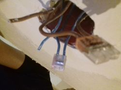 Przewody elektryczne w puszce na ścianie.
