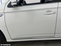 White hybrid car viewed from the side, focusing on the door and side mirror.