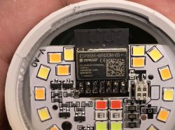 Close-up of an electronic board with an ESP8266-WROOM-05 module and LED lights.