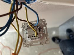 Przewody elektryczne podłączone do mechanizmu włącznika światła w puszce podtynkowej.