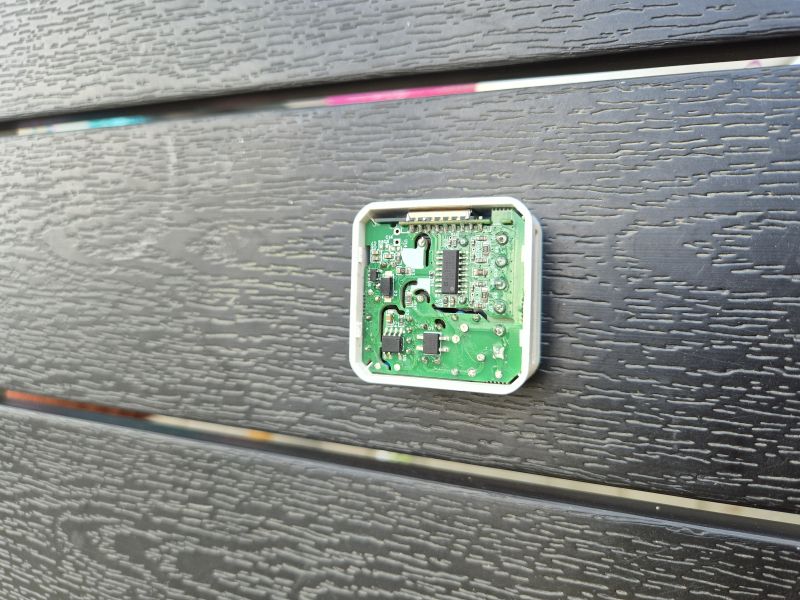 Open casing with a green PCB mounted on black textured boards