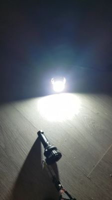 Stara żarówka ledowa H8 po modyfikacji, świecąca na podłodze.