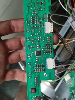 Zbliżenie na płytkę drukowaną z elektroniką trzymaną w brudnej dłoni.