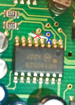 Zbliżenie PCB z układem scalonym i czerwono‑niebieskimi oznaczeniami przy pinach