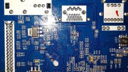 Widok zbliżony na niebieską płytę drukowaną z komponentami elektronicznymi.