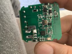 Interior of an electronic device with a visible switch and components on a green PCB.