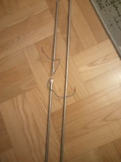 Grzałka elektryczna z przewodami na podłodze z paneli drewnianych.