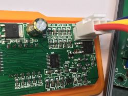 Zbliżenie na fragment płytki drukowanej stacji lutowniczej T12 z widocznymi elementami elektronicznymi, złączem i przewodami.